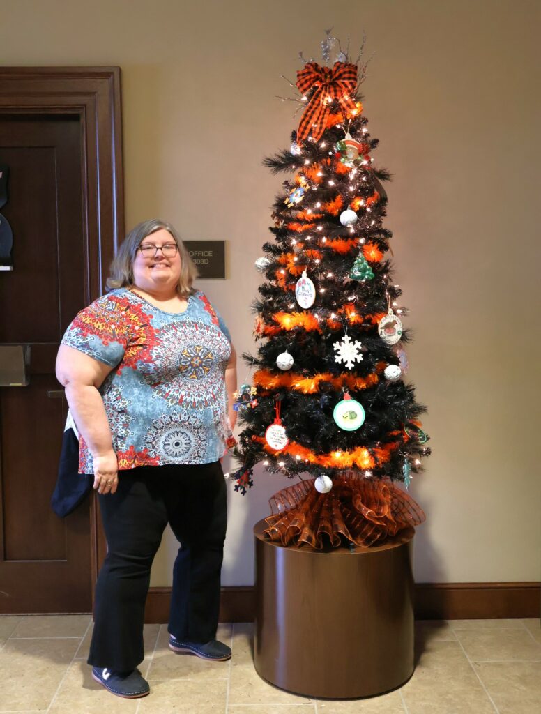 Audrey Brackens stands by the tree in the office lobby for her, Dr. Heather Henson-Ramsey and Kim Carter. 
