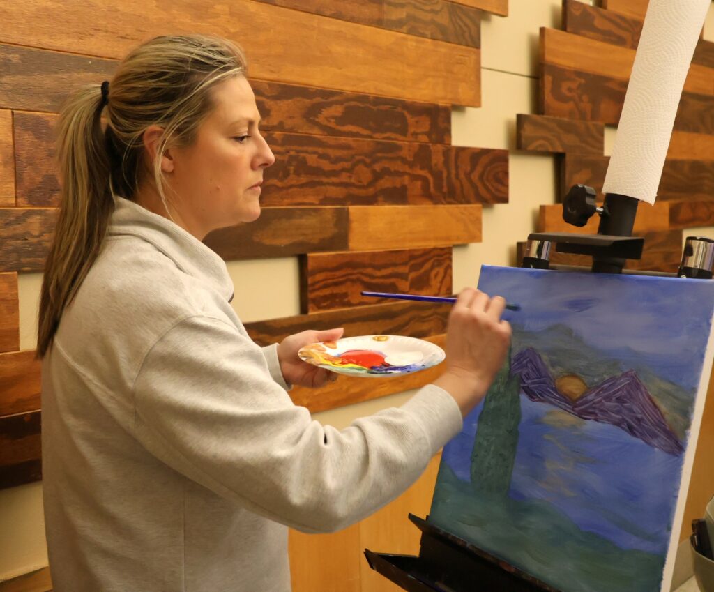 An attendee paints.
