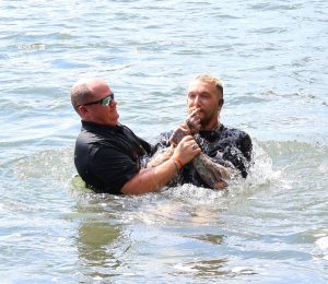 The Rev. E.J. Swatsell, left, baptizes Dare Crusade in the Nolichucky River.