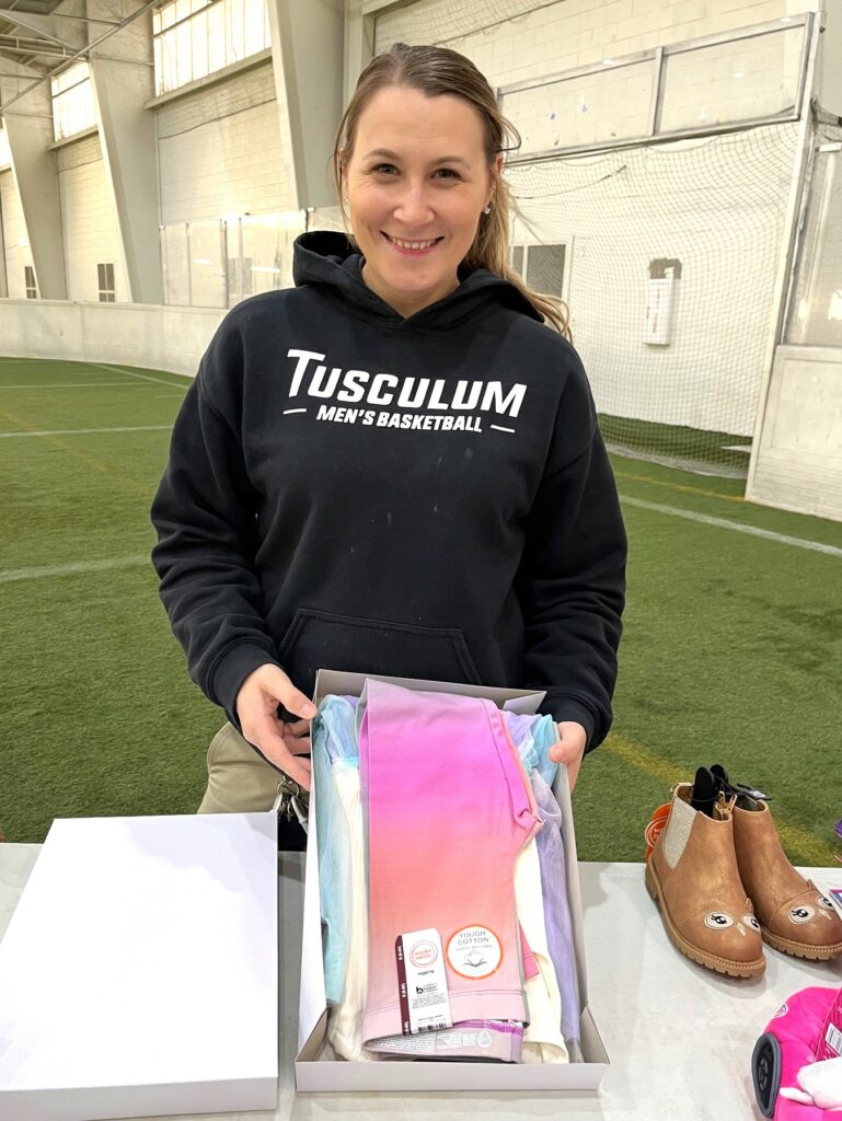 Trinity Velasco shows off one of the gifts she is wrapping.