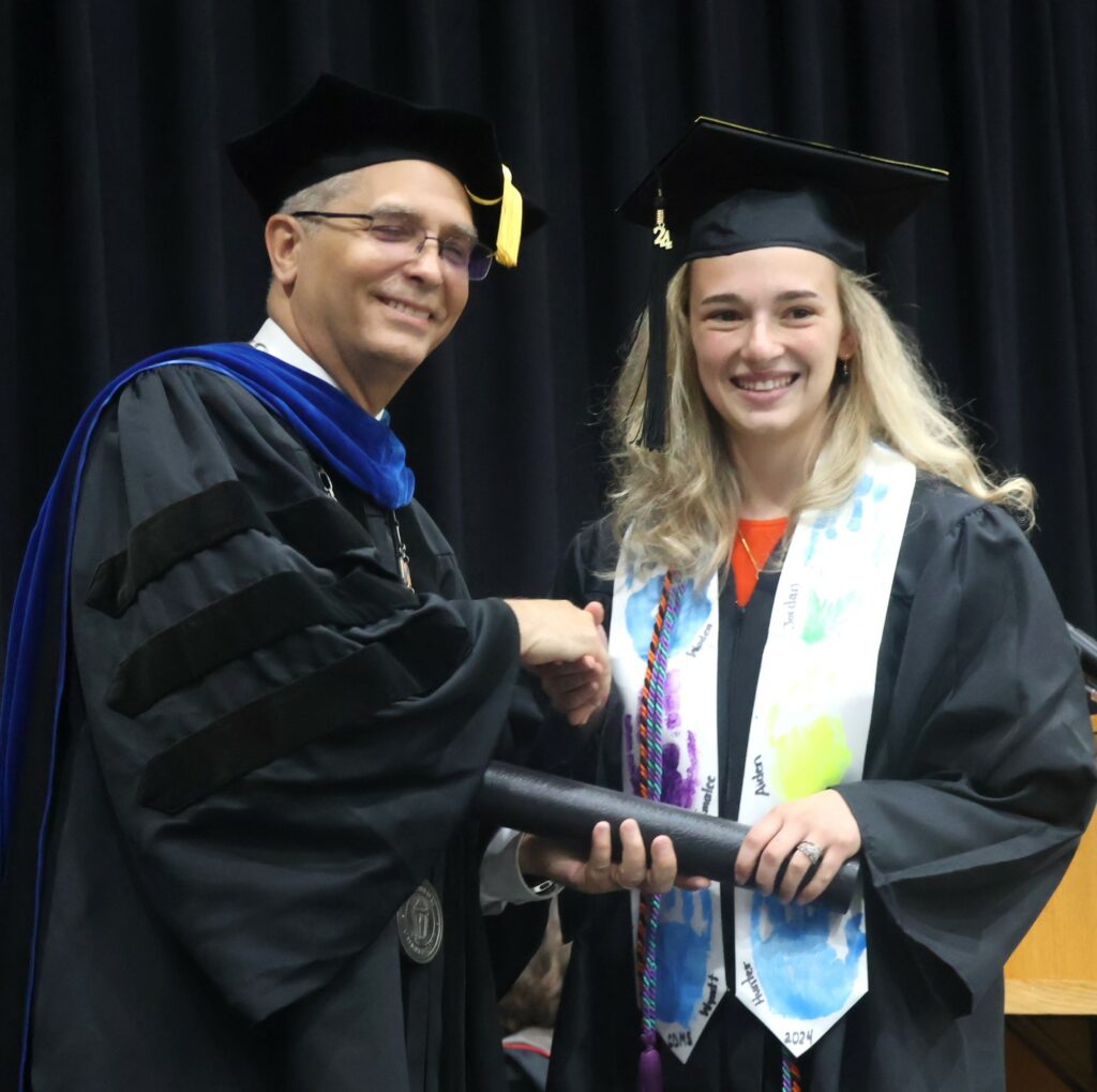 Dr. Hummel, left, congratulates a graduate.