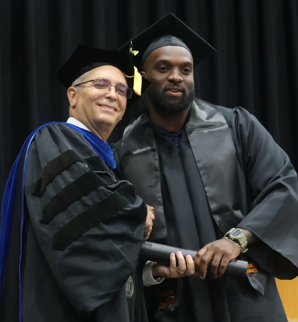 Dr. Hummel, left, congratulates a graduate.
