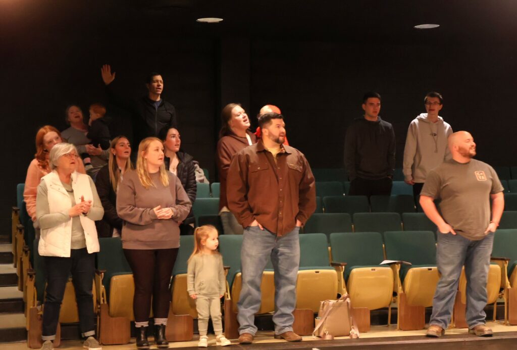 Community members sing as the music plays.