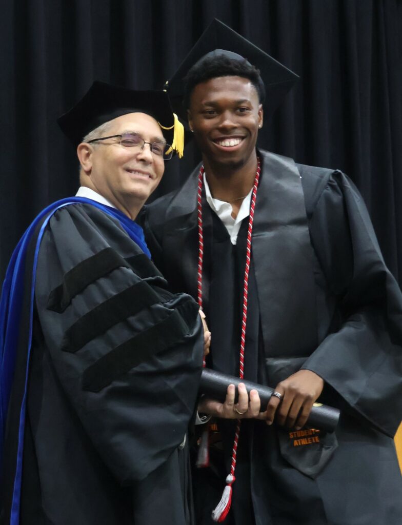 Dr. Hummel, left, congratulates a graduate.