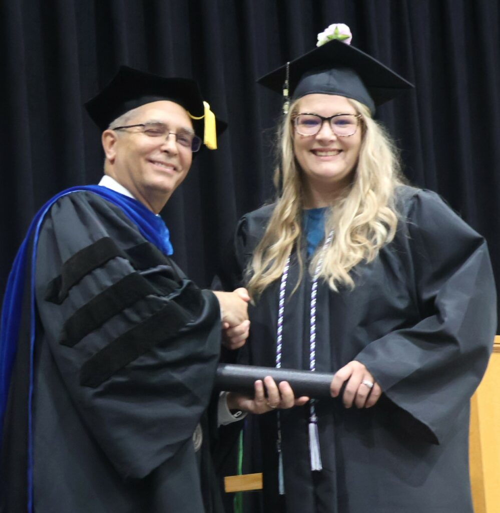 Dr. Hummel, left, congratulates a graduate.