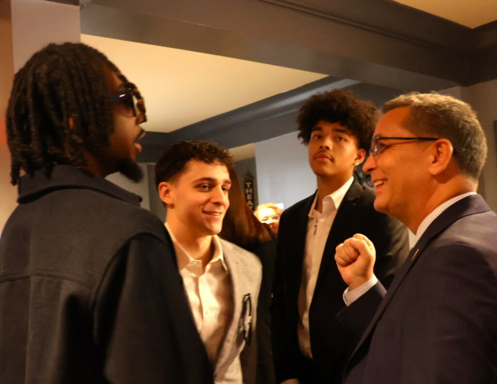 Dr. Scott Hummel, right, speaks with Tusculum men's basketball players afterward.
