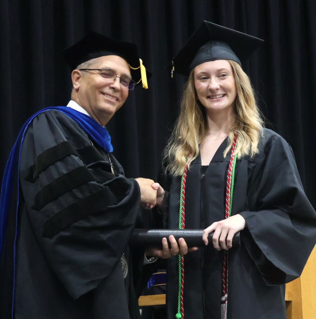 Dr. Hummel, left, congratulates a graduate.