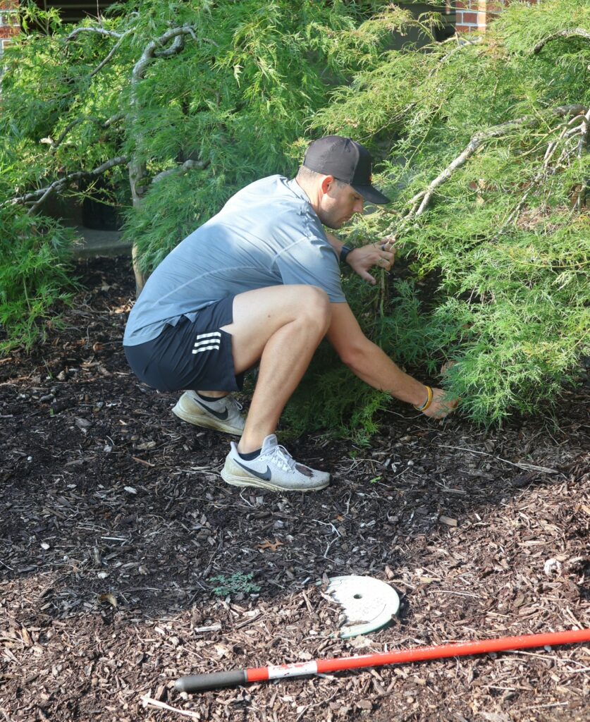 Another employees performs landscaping.