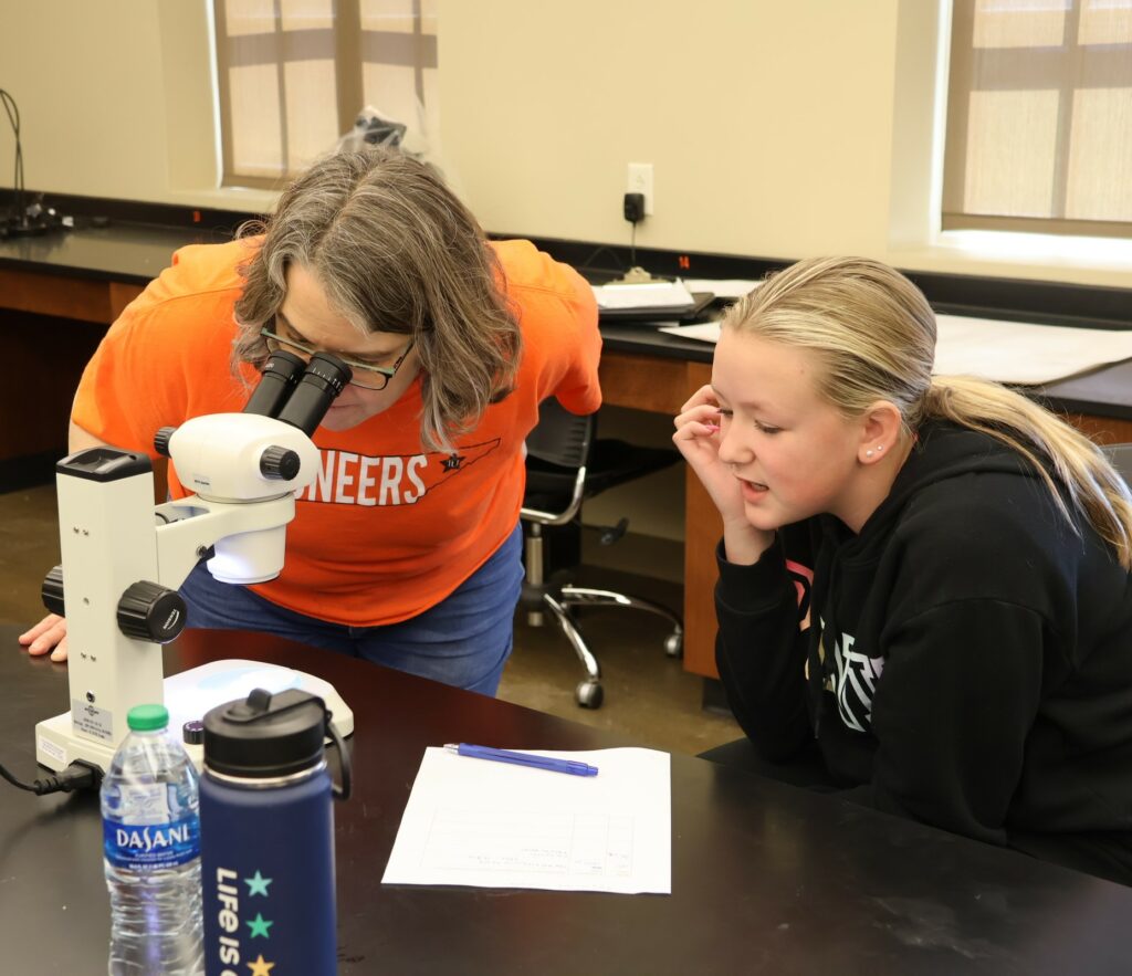 Dr. Heather Henson-Ramsey looks through the microscope.