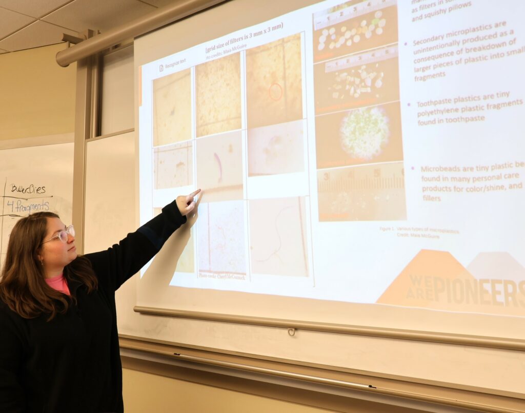 Tusculum student Skylar Lane points to an item on the screen.