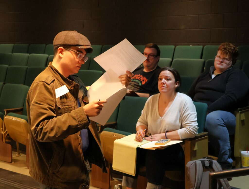 Neal Seefeldt, left, reviews a script while directors look on.