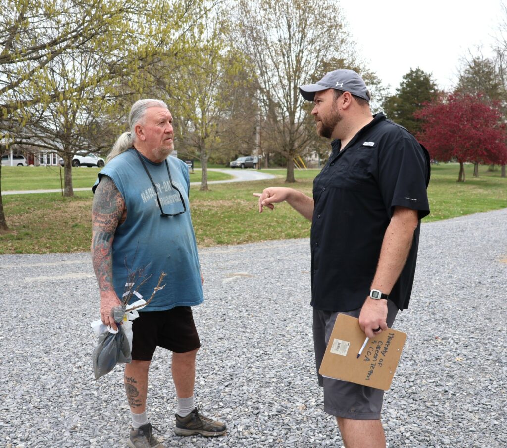 Community member Jim Foster, left, speaks with Jordan Baker, assistant professor of biology at Tusculum.