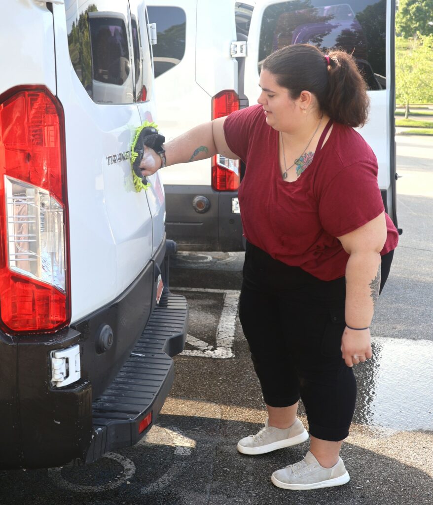 Katie Odoms washes a vehicle.