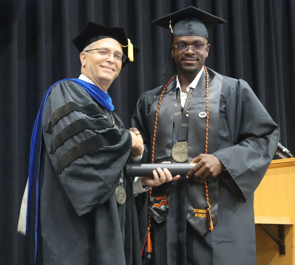 Dr. Hummel congratulates a graduate.