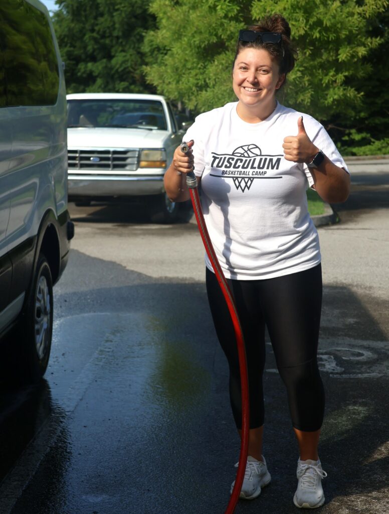 Michala Hash, an assistant women’s basketball coach, has fun washing university vehicles.