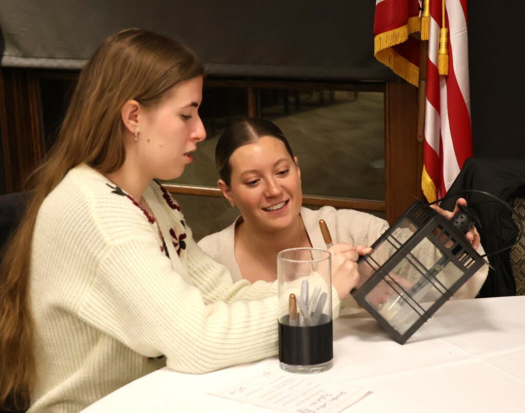 AnnaLee Simpson signs the lantern presented to her by Evie Winfrey.