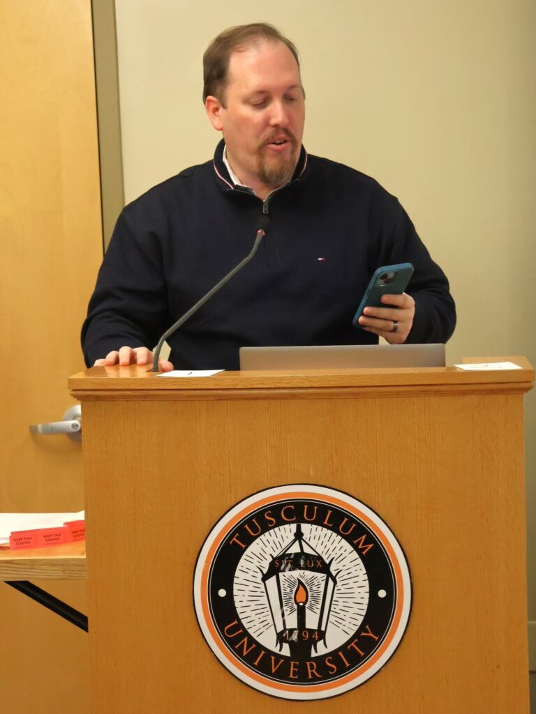 Dr. David Cook reads a Bible passage.