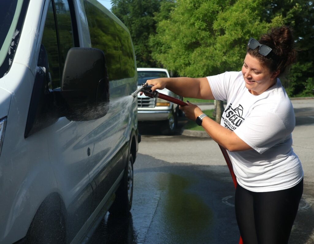 Michala Hash, an assistant women’s basketball coach, washes one of the university vehicles.
