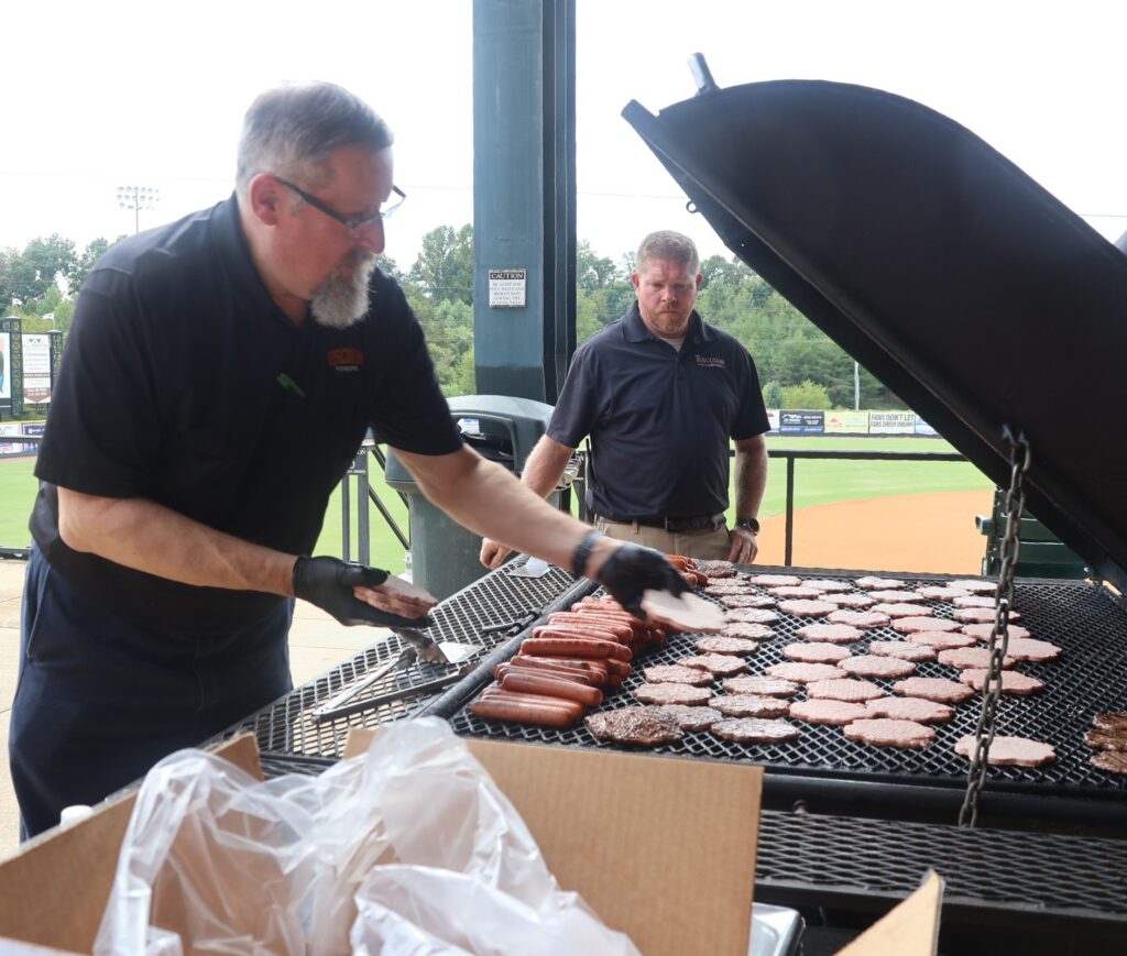 Dean Zoch, left, cooks the hamburgers and hot dogs with assistance from Chad Grindstaff.