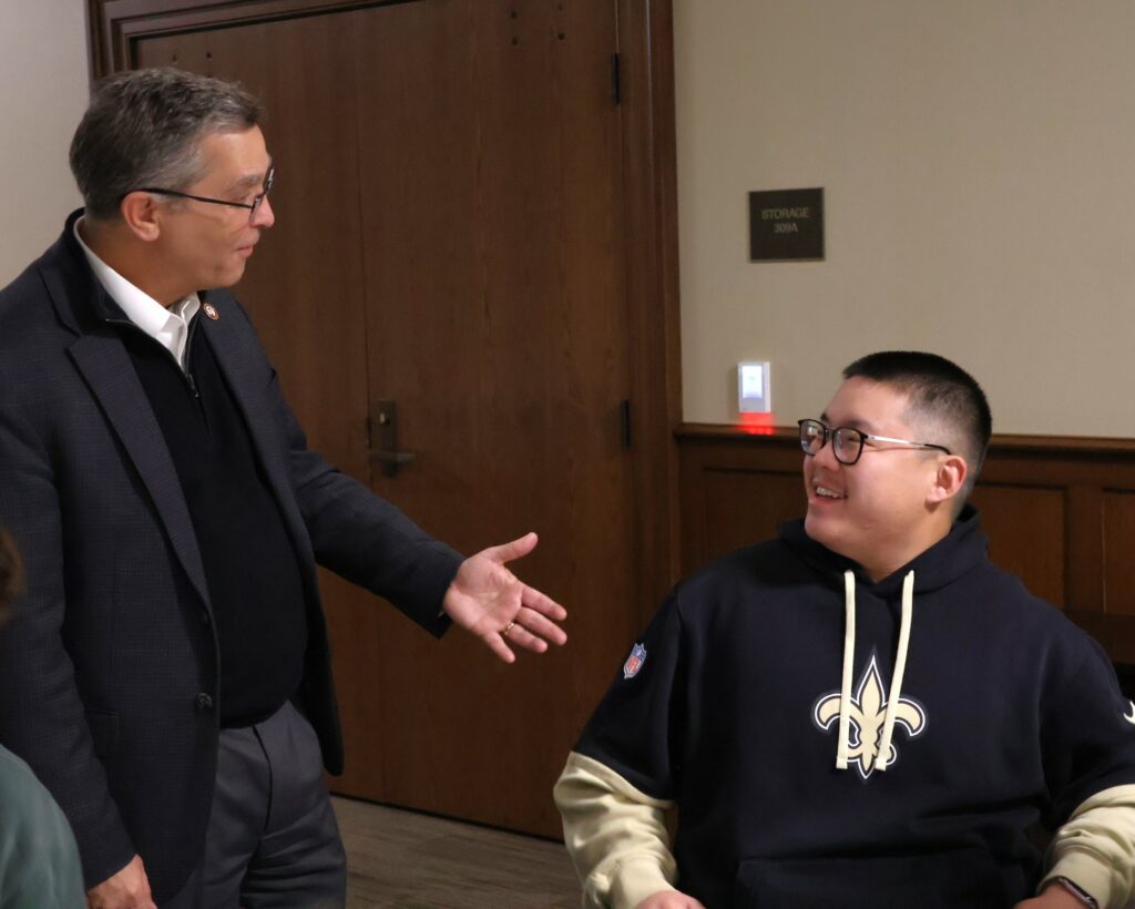 Dr. Scott Hummel, left, speaks with Daniel Wan, a student and fellow New Orleans Saints fan.