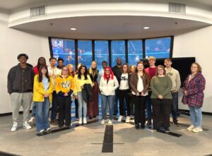 Tusculum University students take a photo with alumna Cassie Born, who is wearing the black shirt in the back. She works for the Nashville Predators.