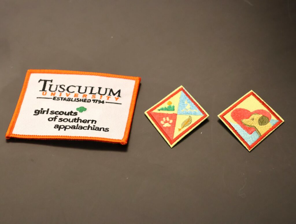 Here are two badges and a patch the Girl Scouts earned during their visit to Tusculum.