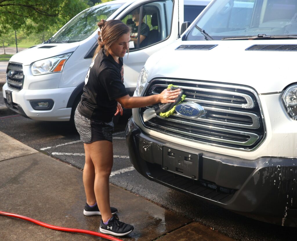 Jenna Biggins washes a university vehicle.