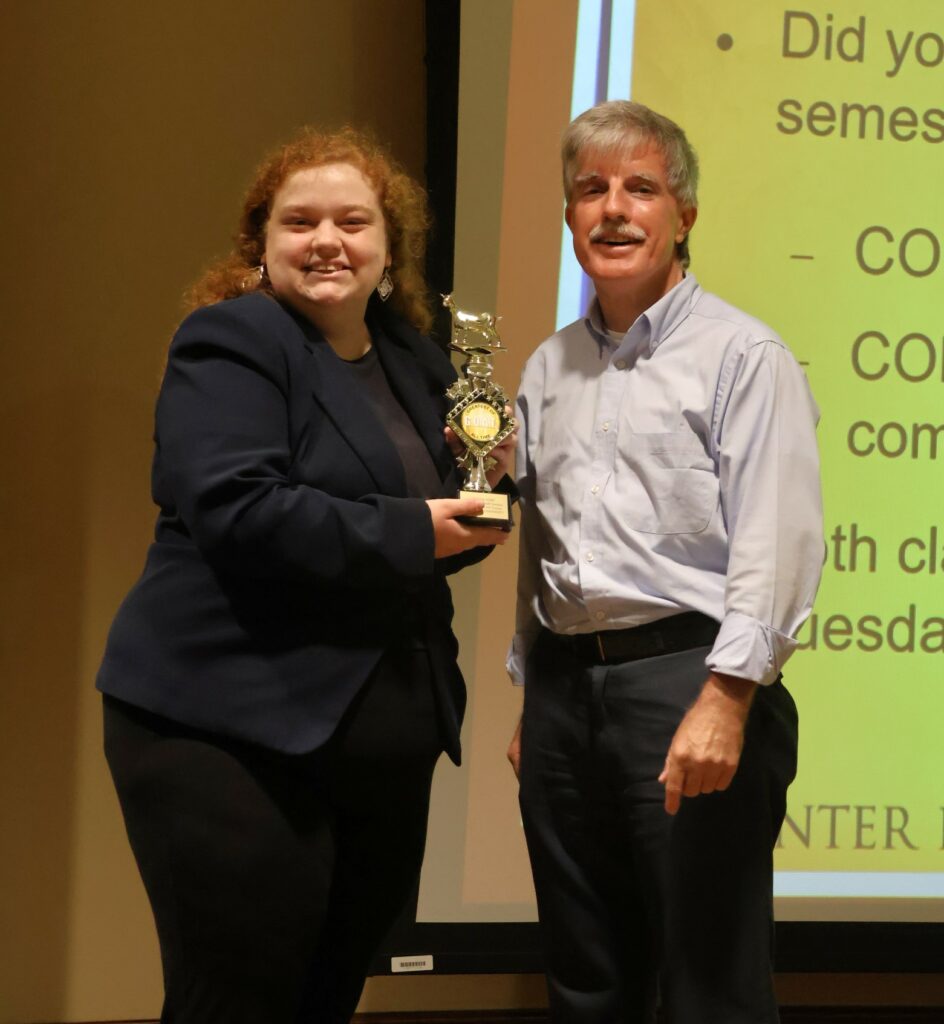 Student Zoey Seay, left, stands with Jim Wozniak, who won the Ye Olde Goat trophy.