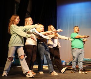 Actors demonstrate enthusiasm during the opening number at a rehearsal.