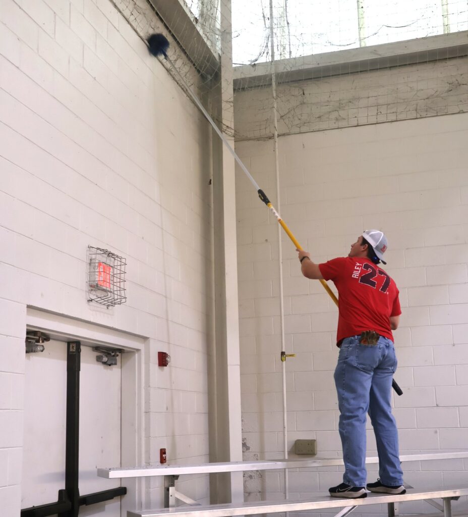An employee cleans a section of wall.