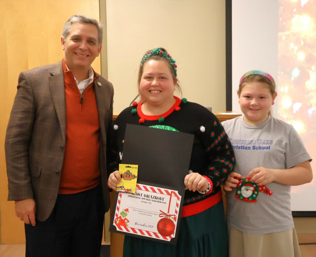 Left to right are Dr. Scott Hummel, Megan Pierce and Lilley Pierce. Megan holds her prize for winning the crazy Christmas apparel contest.