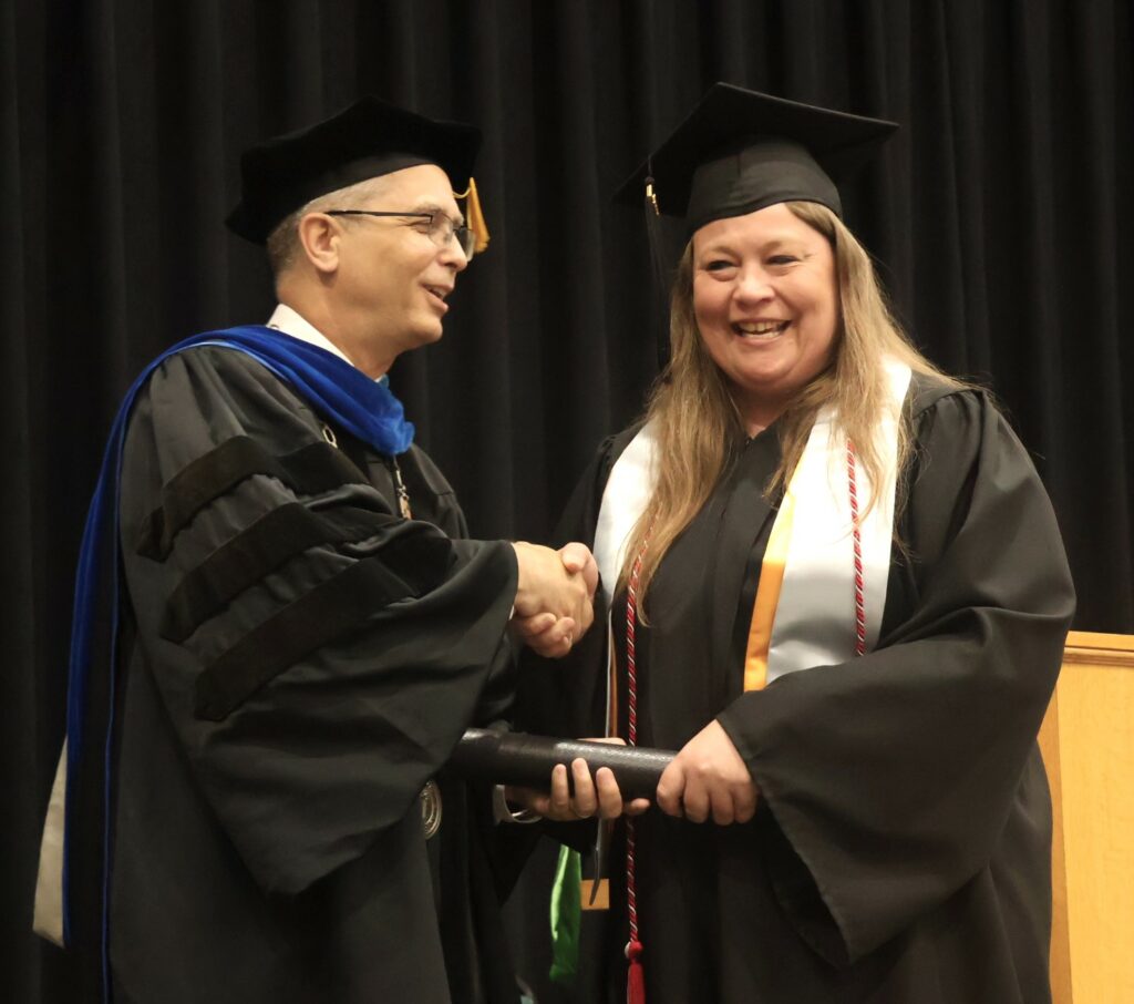 Dr. Hummel, left, congratulates a graduate.