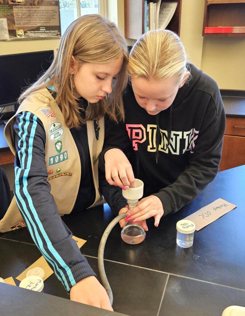 Girl Scouts filter a water sample.