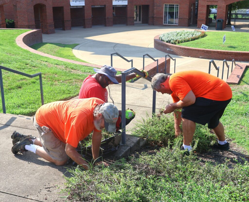 Clockwise from bottom left, Todd Hertel, Steve Anderson and Billy Taylor work on landscaping.