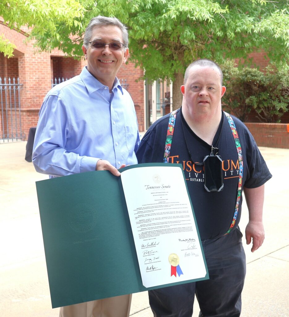 Dr. Hummel holds the resolution honoring Travis Parton, right.