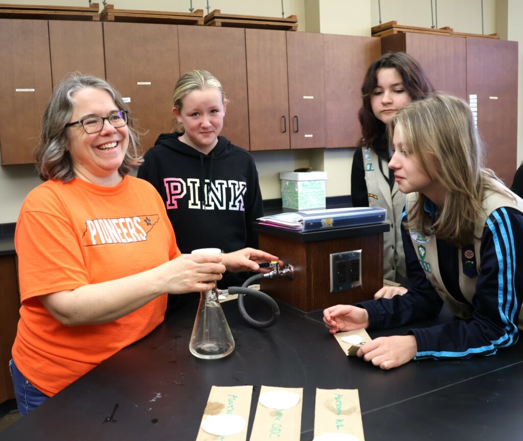 Dr. Heather Henson-Ramsey, left, works with three Girl Scouts on microplastics.