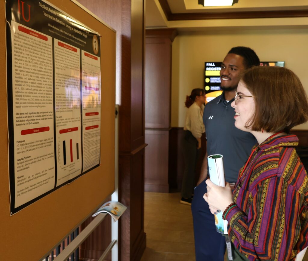 Adrian Robinson, left, discusses his poster with Emme Foster.