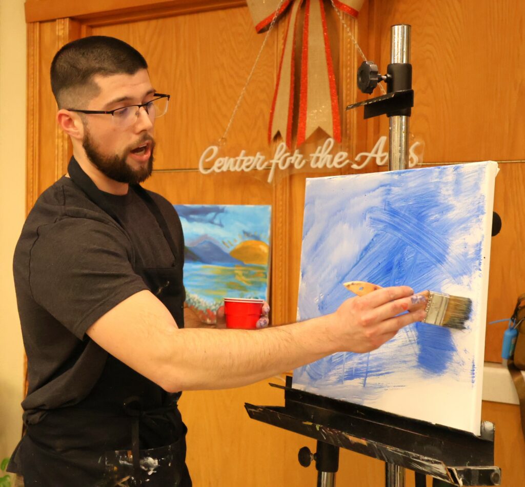 Benjamin Conley paints.