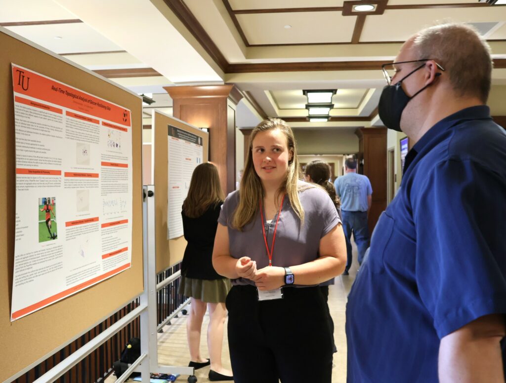 Emma Harriman, left, discusses her poster with Walter Wimberly.