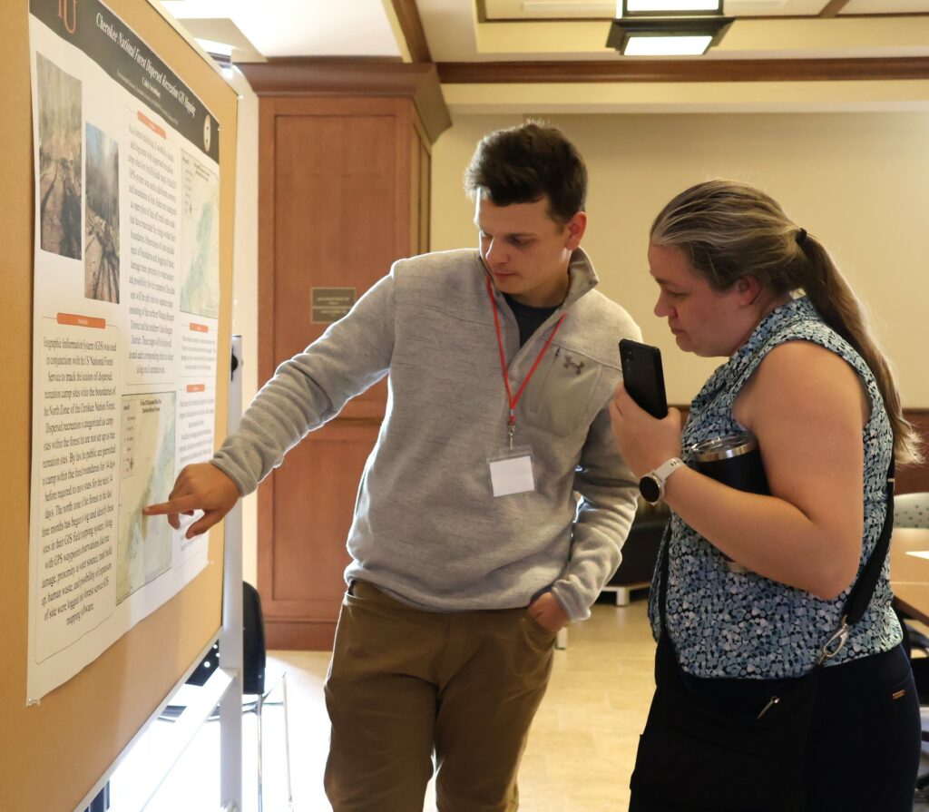 Caleb Swinehart, left, discusses his poster with Dr. Hollie Pellosmaa.