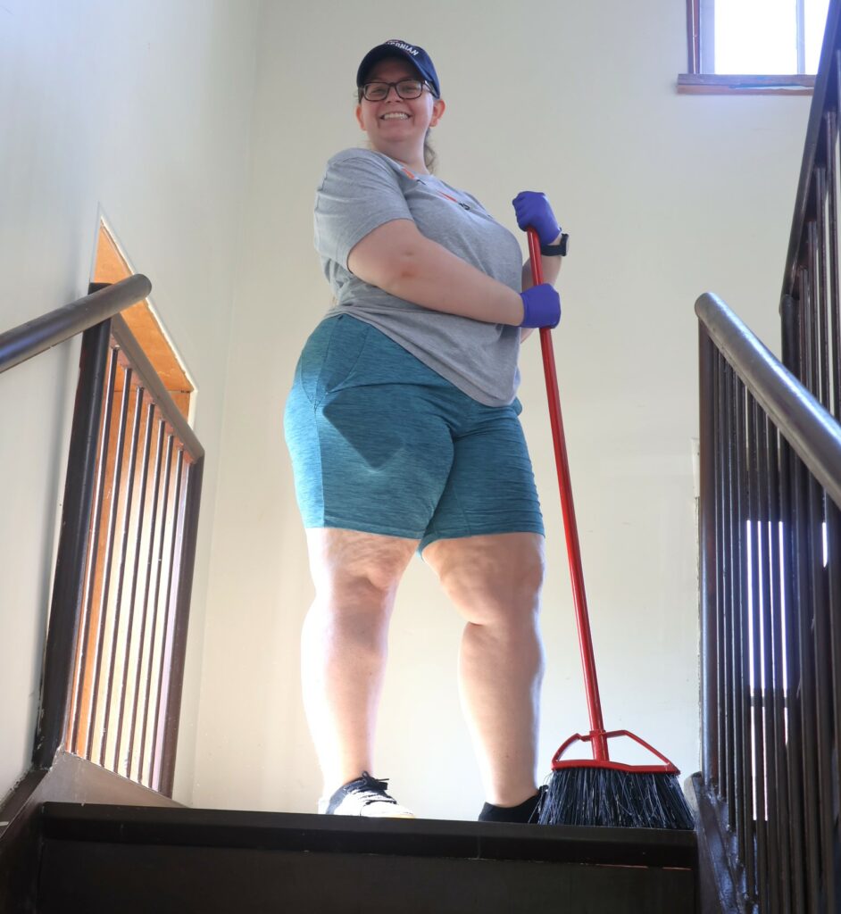 Laura Carr takes a break from sweeping stairs.