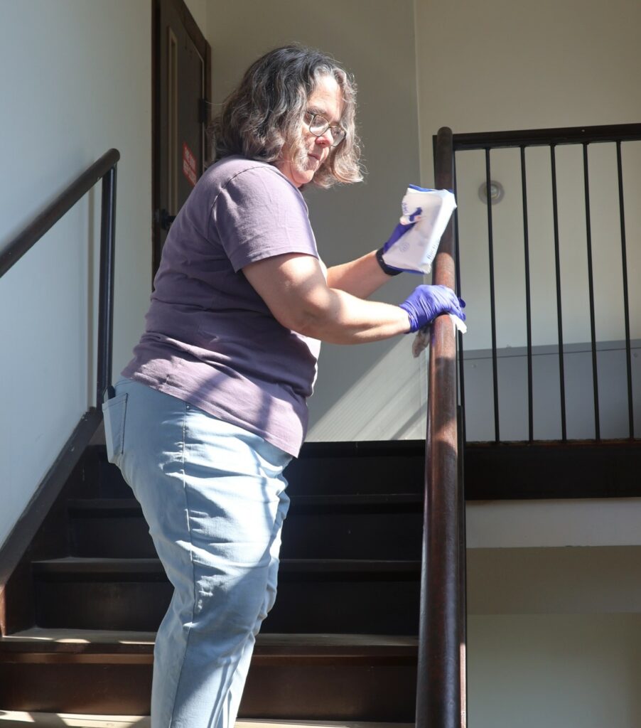 Dr. Heather Henson-Ramsey wipes a rail.