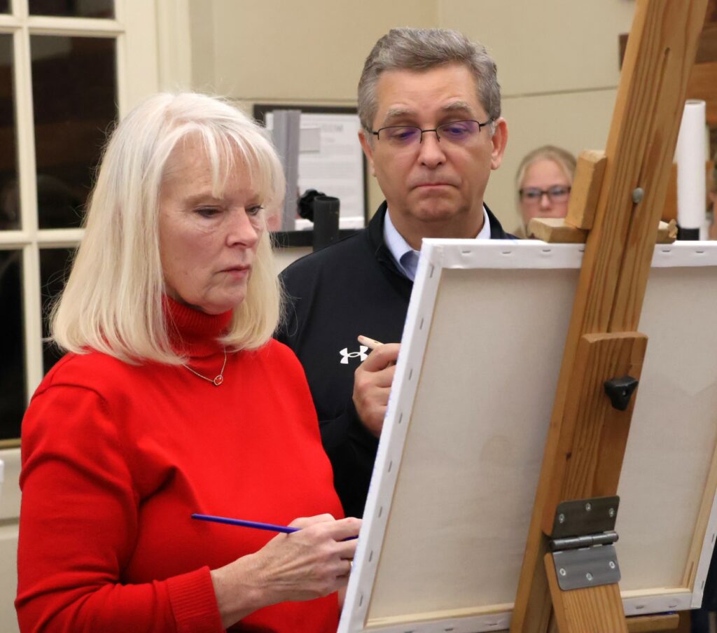 Dr. Scott Hummel and Starr Hummel look over their painting.