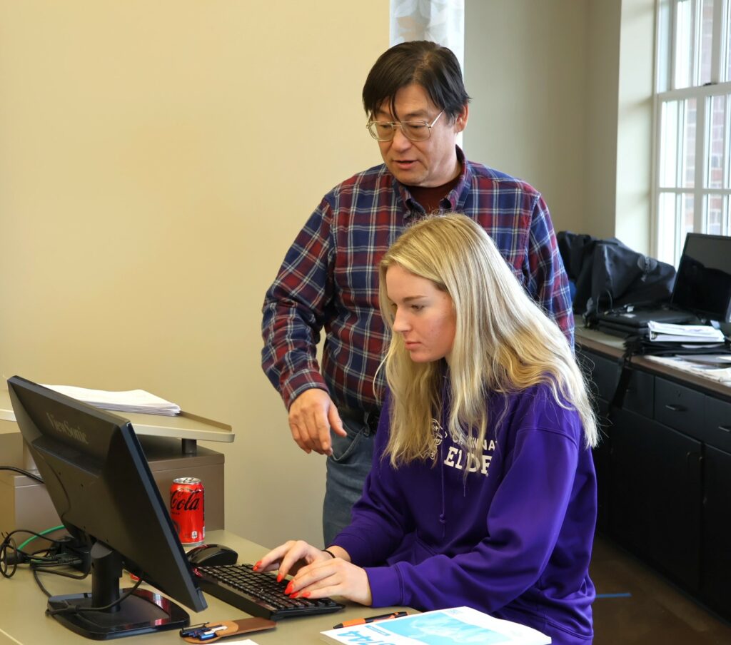 Dr. Harold Branstrator, standing, instructs a student.