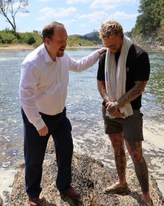 Dr. David Cook, left, prays for Dare Crusade after the baptism.