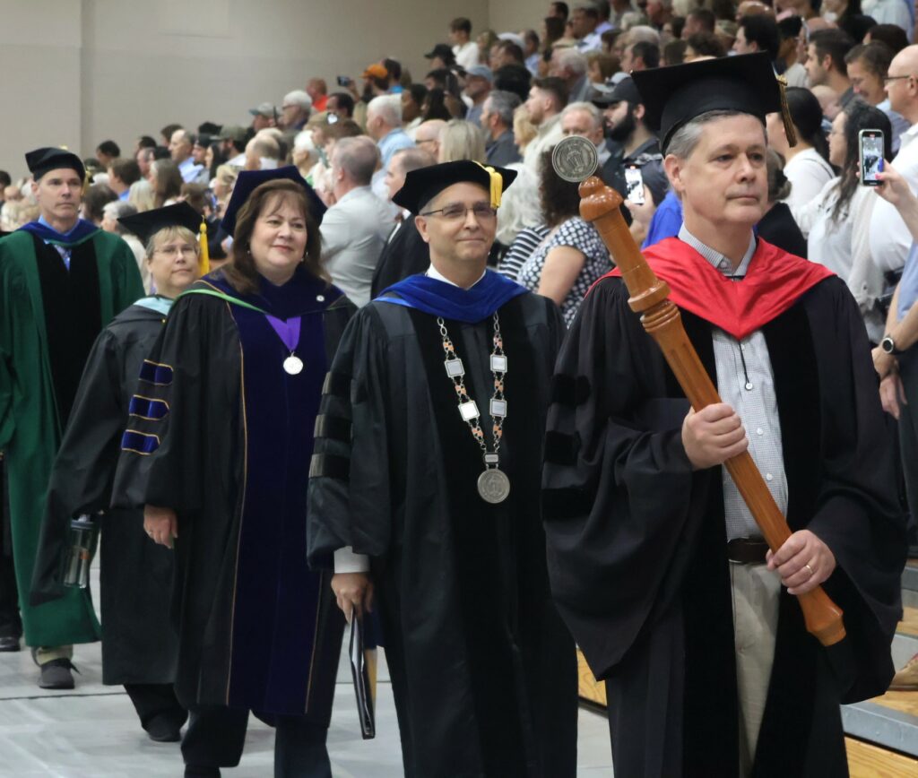 Members of the platform party enter. They are, left to right, Dr. Kevin Hill, Jill Oberfeitinger, Dr. Tricia Hunsader, Dr. Scott Hummel and Dr. Joel Van Amberg.