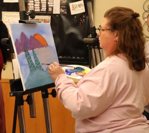 A woman creates her painting.