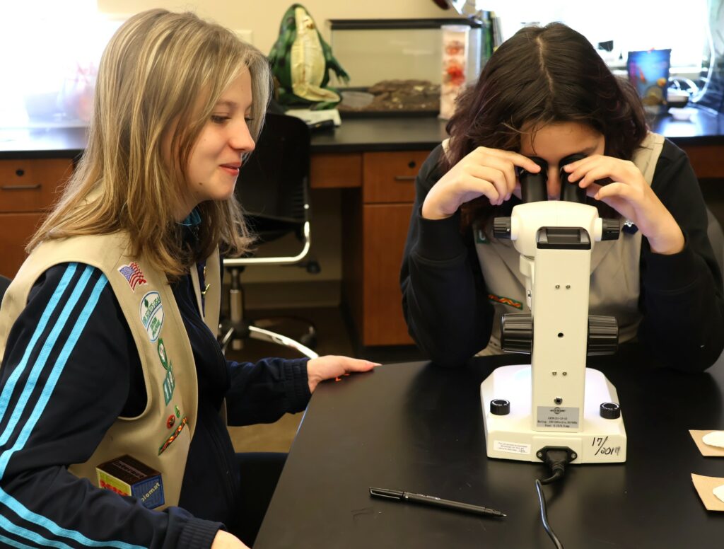 Two Girl Scouts examine water samples.