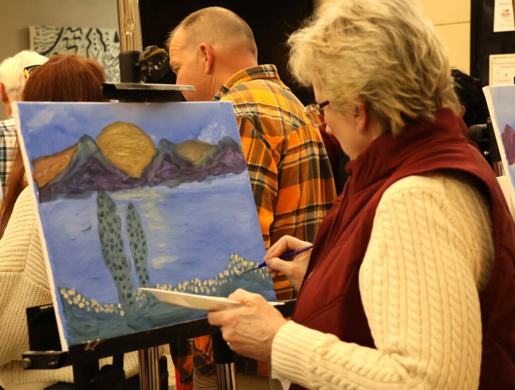 An attendee paints.
