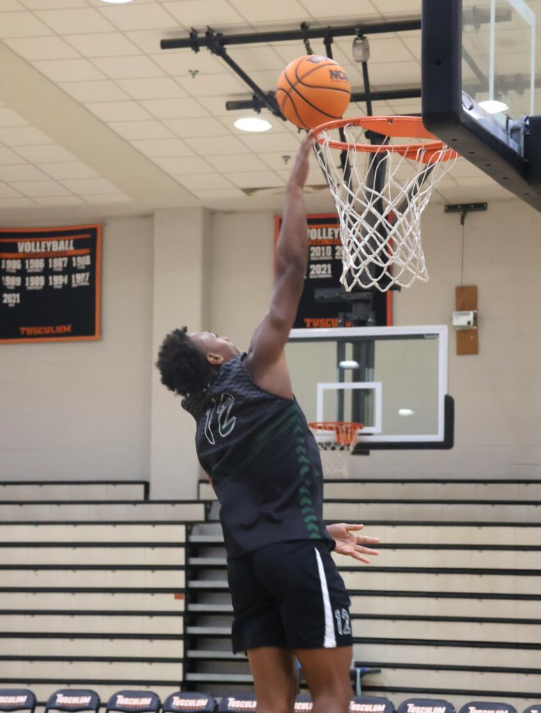 A player takes the ball to the hoop during warmup.
